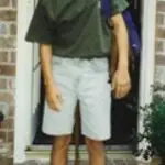 photo of 12 year old boy in green shirt and denim shorts