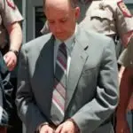 man in handcuffs in gray suit and tie