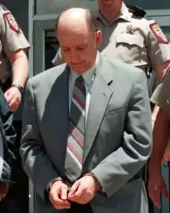 man in handcuffs in gray suit and tie