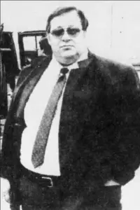 large man in suit and dark glasses